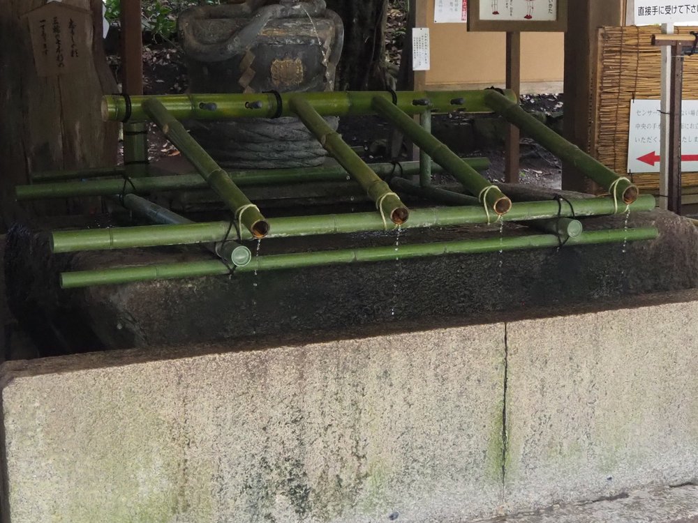 Bamboo water spouts and dippers at the Omiwa Shrine purification fountain