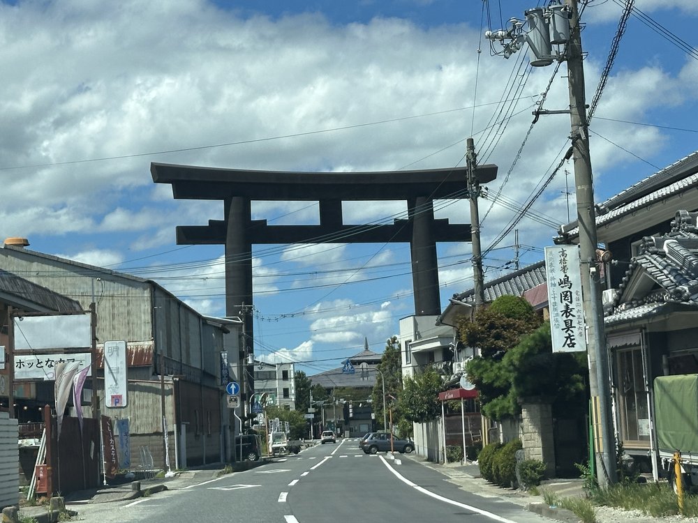 A wide view of Omiwa Shrine's great torii framing the road approach
