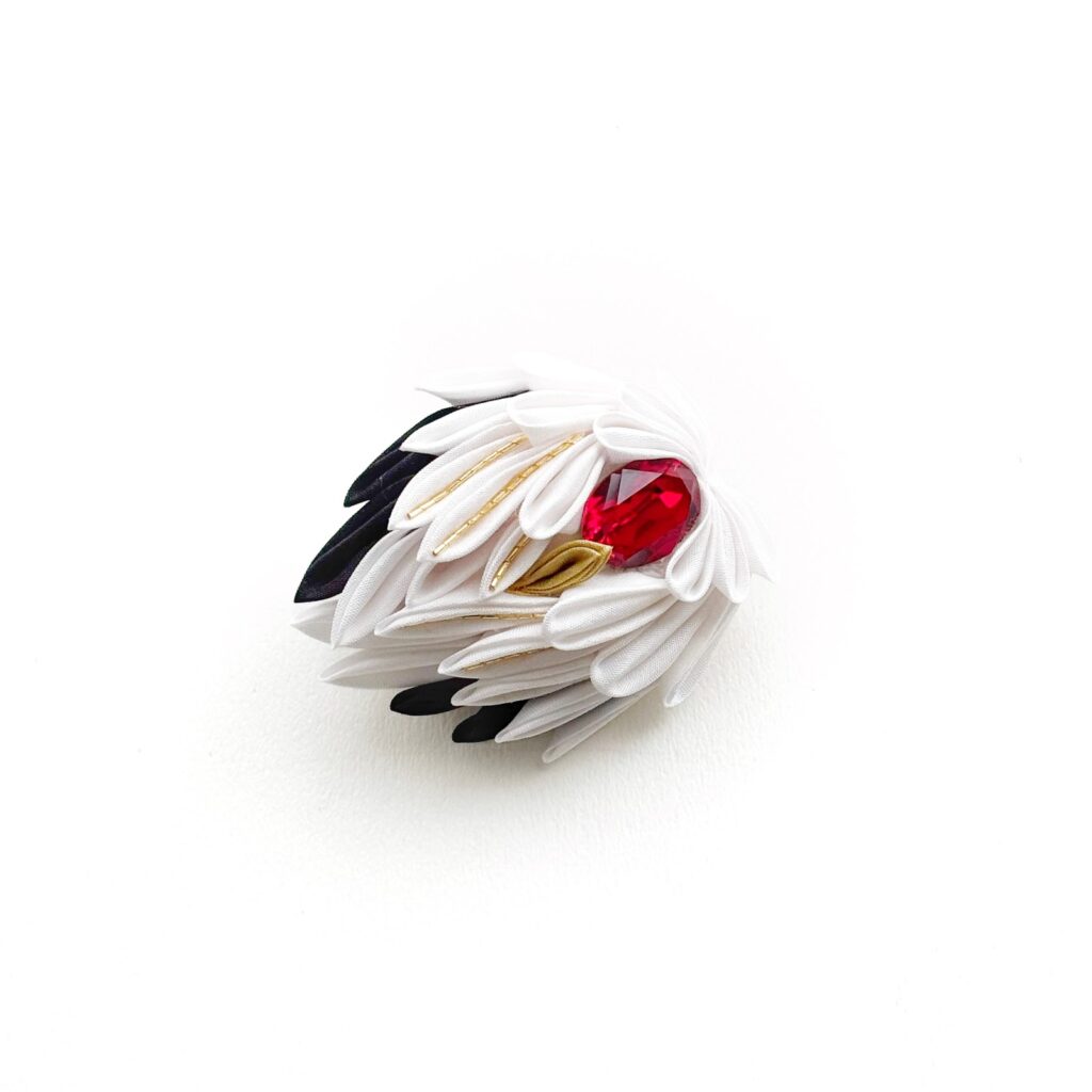 White and black tsumami zaiku crane brooch with a red jewel by Tsumami Kanzashi Ayano