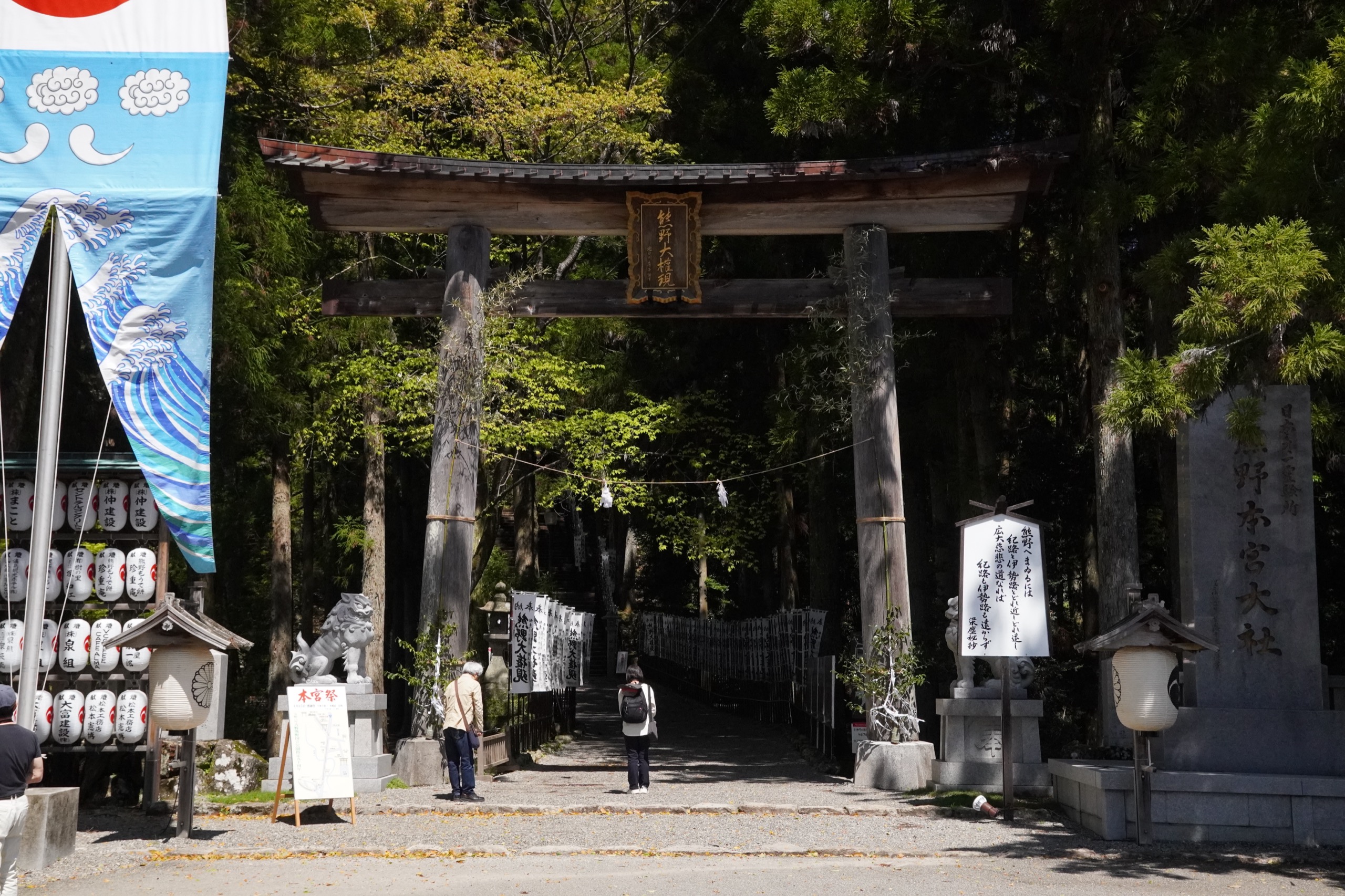 Wooden entrance torii of Kumano Hongu Taisha with festival banners and Yatagarasu three-legged crow flags