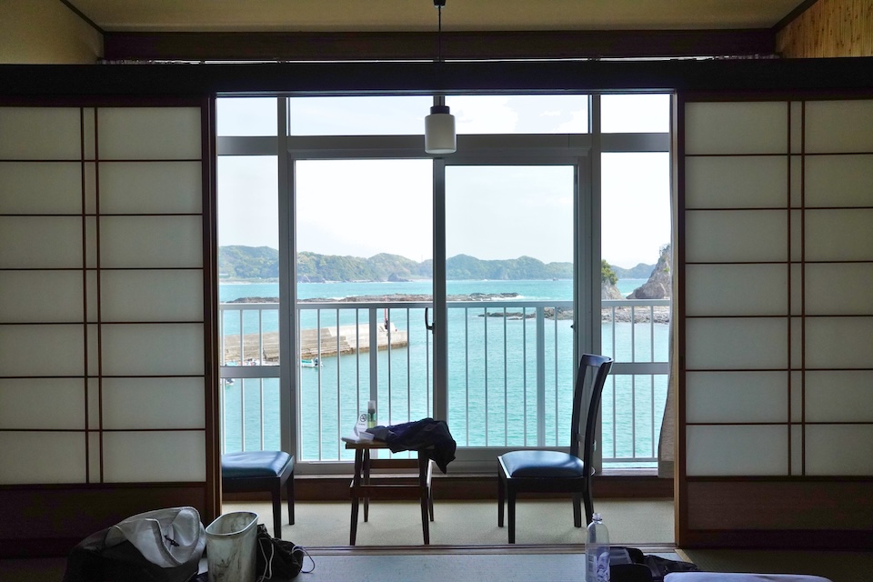 A tatami guest room at a sea-facing inn in Kii-Katsuura looking out over the bay