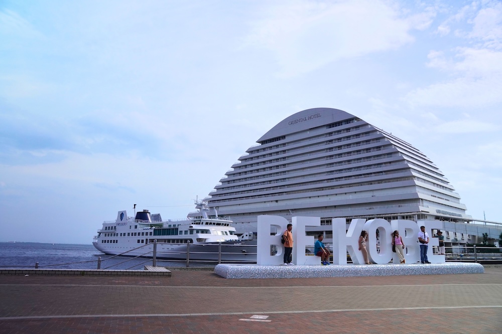 The BE KOBE monument in Meriken Park with the Kobe Meriken Park Oriental Hotel and a cruise ship behind it