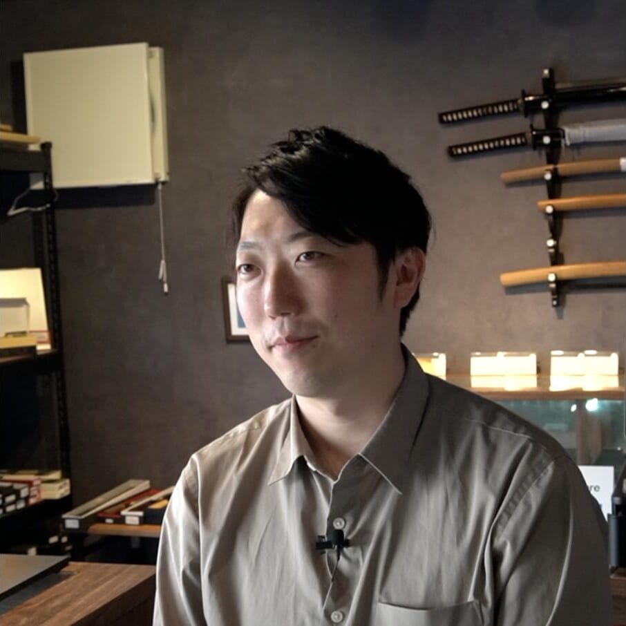 Koji Inohara, CEO of Blacksmith Japan, in his shop in Seki with Japanese swords on the wall behind him