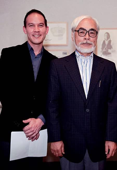 Two men in dark suits standing side by side in a gallery