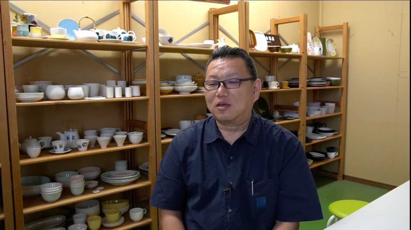 Product designer Shotaro Shibata in Miyama's sample room lined with porcelain tableware